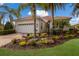 House exterior featuring a white facade, terracotta roof, and lush landscaping at 14614 Newtonmore Ln, Lakewood Ranch, FL 34202