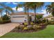 Single-story home with white walls, tile roof, and landscaped front yard at 14614 Newtonmore Ln, Lakewood Ranch, FL 34202