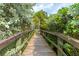 Wooden boardwalk path through lush tropical landscaping at 1519 Pelican Point Dr # 191, Sarasota, FL 34231