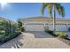 Two-car garage with paver driveway and lush landscaping at 1910 Scarlett Ave, North Port, FL 34289