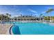 Community pool with lounge chairs and clubhouse at 1910 Scarlett Ave, North Port, FL 34289