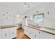 Bright kitchen with white cabinets, a double sink, and wood-look flooring at 2107 Palma Sola Blvd # 13, Bradenton, FL 34209