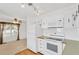 White kitchen appliances and cabinets with a view into the dining area at 2107 Palma Sola Blvd # 13, Bradenton, FL 34209