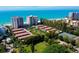 Aerial view of beachfront property, tennis courts, and parking at 2301 Gulf Of Mexico Dr # 52N, Longboat Key, FL 34228