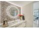 Modern bathroom with a large round mirror and a plant at 2301 Gulf Of Mexico Dr # 52N, Longboat Key, FL 34228