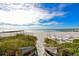 Beach access walkway with wooden railing and beach chairs at 2301 Gulf Of Mexico Dr # 52N, Longboat Key, FL 34228