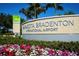 Signage displaying the Sarasota Bradenton International Airport name set amongst landscaping, flowers, and greenery at 2335 Novus St, Sarasota, FL 34237