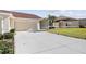 Front view of a beige house with a two-car garage and well-manicured lawn at 2608 Edgewater Ct, Palmetto, FL 34221