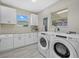 Laundry room with washer, dryer, and white cabinets at 330 Caruso Pl, Sarasota, FL 34237