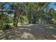 Wooded backyard with tropical plants and small enclosure at 3395 Hardee Dr, Venice, FL 34292