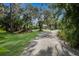 Gravel driveway with tropical landscaping and trees at 3395 Hardee Dr, Venice, FL 34292