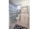 Clean bathroom with white vanity, shower, and geometric patterned curtain at 3951 Lake Bayshore Dr # F408, Bradenton, FL 34205