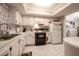 White kitchen with black appliances and tile flooring at 3951 Lake Bayshore Dr # F408, Bradenton, FL 34205