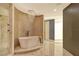 Luxurious bathroom featuring a freestanding soaking tub and marble tile at 415 L Ambiance Dr # A401, Longboat Key, FL 34228