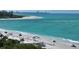 Beachfront view with umbrellas and turquoise water at 415 L Ambiance Dr # A401, Longboat Key, FL 34228