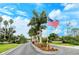 Community entrance with lush landscaping and American flag at 4250 Players Pl # 2615, Sarasota, FL 34238