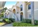 Two-story condo building with stairs, landscaping, and a blue door at 4250 Players Pl # 2615, Sarasota, FL 34238