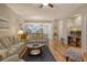 Living room with hardwood floors, striped couches, and a view of the kitchen at 4250 Players Pl # 2615, Sarasota, FL 34238