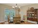 Charming dining area with wood floors, glass table, classic china cabinet, and sliding glass doors leading to the pool at 429 N Rossetti Dr, Nokomis, FL 34275