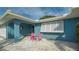 Front yard with a blue facade and a quaint pink patio set that adds a cheerful pop of color at 429 N Rossetti Dr, Nokomis, FL 34275