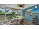 Relaxing screened patio with tiled flooring, ceiling fan, and lush backyard views at 429 N Rossetti Dr, Nokomis, FL 34275