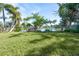 Landscaped backyard with lake access and a wooden dock at 4515 Falcon Ridge Dr, Sarasota, FL 34233