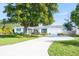 White house with green accents and a spacious driveway at 4515 Falcon Ridge Dr, Sarasota, FL 34233