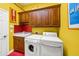 Laundry room with washer, dryer, and wood cabinets at 4850 Sweetshade Dr, Sarasota, FL 34241