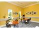 Inviting common area with cafe tables, natural light and decorative art on yellow walls at 5208 Parisienne Pl # 202B33, Sarasota, FL 34238