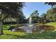 Scenic pond with fountain feature, surrounded by lush landscaping and mature trees at 5208 Parisienne Pl # 202B33, Sarasota, FL 34238