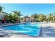 Community pool with lounge chairs and tables for relaxation and poolside enjoyment on a sunny day at 5208 Parisienne Pl # 202B33, Sarasota, FL 34238