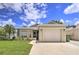 House exterior featuring a beige one-story home with a two-car garage and a well-maintained lawn at 6115 39Th W Ave, Bradenton, FL 34209