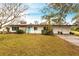 White single story home with teal door, landscaped lawn, and attached two-car garage at 6222 Brentwood Ave, Sarasota, FL 34231