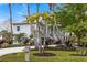 Two-story house with tropical landscaping and a gated driveway at 6821 Longboat S Dr, Longboat Key, FL 34228