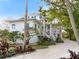 White two-story house with a large porch and tropical landscaping at 6821 Longboat S Dr, Longboat Key, FL 34228