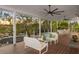 Relaxing covered porch overlooking the water with outdoor furniture at 6821 Longboat S Dr, Longboat Key, FL 34228