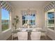 Bright dining room with glass table, chandelier, and lake view at 719 Maldives Trl, Sarasota, FL 34234