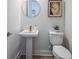 Small powder room with pedestal sink and toilet at 719 Maldives Trl, Sarasota, FL 34234