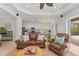 Spacious living room featuring a brown leather sofa and comfortable armchair at 7204 Annanhill Ln, Lakewood Ranch, FL 34202