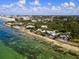 Aerial view of coastline, ocean and houses on a sunny day at 7314 Point Of Rocks Rd, Sarasota, FL 34242