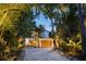 Attractive home with a large wooden garage door and tropical landscaping at 7314 Point Of Rocks Rd, Sarasota, FL 34242