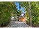 Coastal home with a wooden garage door and tropical landscaping at 7314 Point Of Rocks Rd, Sarasota, FL 34242