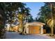 Beach style home with a charming wooden garage door and lush landscaping at 7314 Point Of Rocks Rd, Sarasota, FL 34242