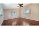 Bright bedroom featuring hardwood floors, ceiling fan, and two windows at 7324 Phillips St, Sarasota, FL 34243