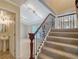 Open entryway featuring stairs with iron railing, half bath, and view into the living room with abundant light at 7324 Phillips St, Sarasota, FL 34243