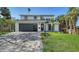 Charming home boasts a manicured lawn, palm trees, and modern garage door, enhancing its curb appeal at 7324 Phillips St, Sarasota, FL 34243