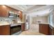 Kitchen featuring stainless steel appliances, dark wood cabinets, marble backsplash and breakfast bar at 7324 Phillips St, Sarasota, FL 34243