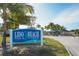 Welcoming Lido Beach Pool & Pavilion sign surrounded by lush greenery and palm trees on a sunny day at 7324 Phillips St, Sarasota, FL 34243