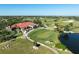 Aerial view of clubhouse, golf course, and adjacent pond at 7503 Calle Facil, Sarasota, FL 34238