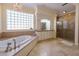 Spa-like bathroom with soaking tub, double vanity, and glass shower at 7503 Calle Facil, Sarasota, FL 34238